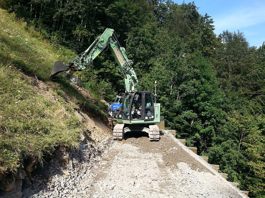 Bagger Hitachi ZX135 mit Maschinen-Target zur Positionsbestimmung mit Tachymeter. Es ist sehr schön, die Neigung des Hanges (38°) und die eingeschränkte Bewegungsfreiheit der Maschine zu sehen.